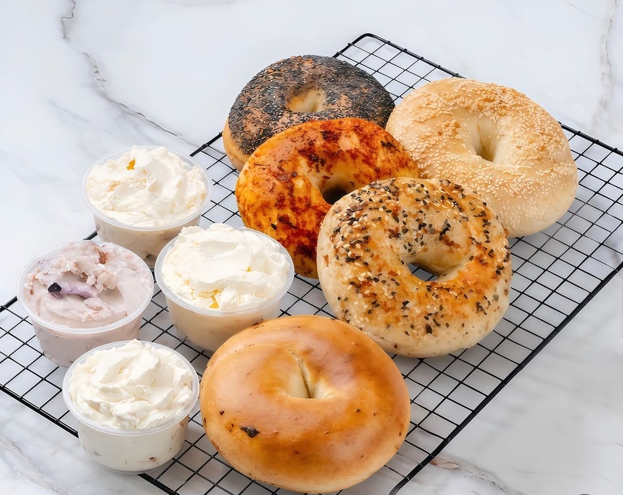 Fresh bagels with tubs of cream cheese