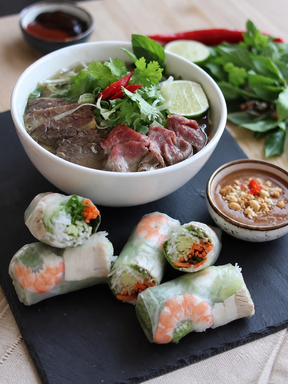 A rice bowl with fresh spring rolls and dipping sauce